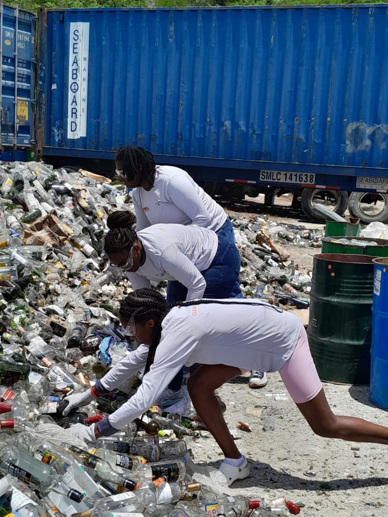 Three women sorting and separating glass bottles